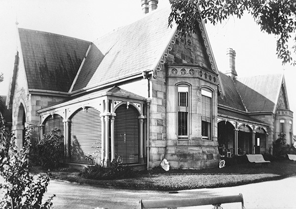 This black and white photograph of the Hamilton Villa 'Eldernell' shows a single storey stone house with steeply pitched gable roofs, bay windows, and verandahs along the side.