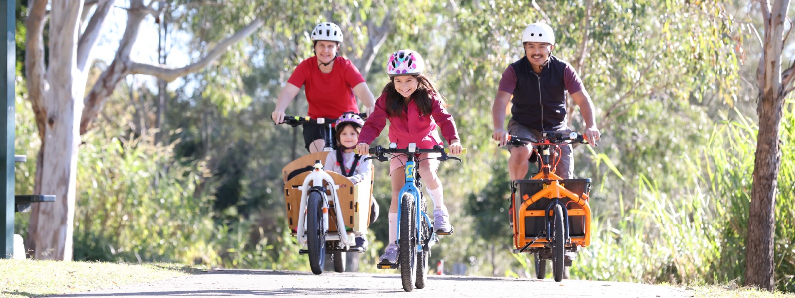 A family cycling through a park