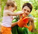 Mother and daughter watering plants with watering can